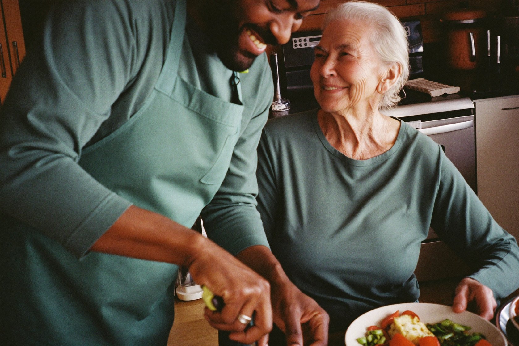 A caregiver serving a home-cooked meal to a senior client
